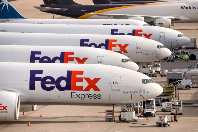 Cargo plane loading packages, symbolizing new FedEx import surcharges on international shipments
